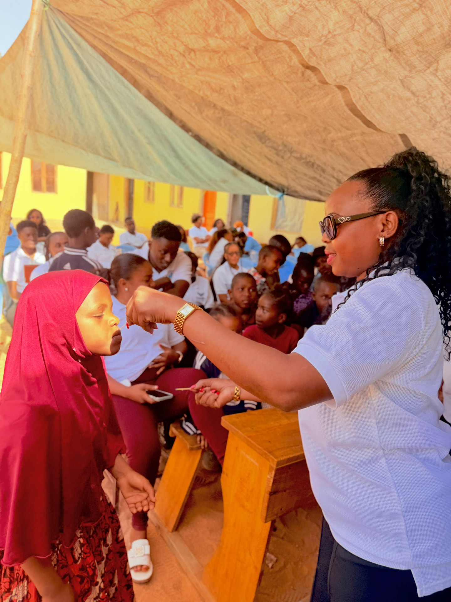 A Visitor Offering Cake to a Student